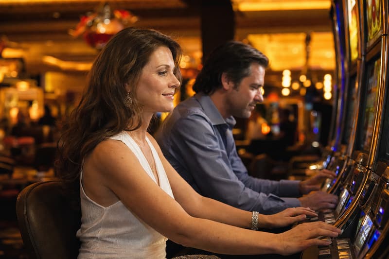 Reihe leuchtender moderner Video-Spielautomaten in einem Casino-Saal